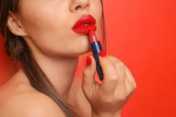 Όμορφη Νεαρή Γυναίκα Εφαρμογή Κόκκινο Κραγιόν Στο Φόντο Χρώμα Closeup — Φωτογραφία Αρχείου