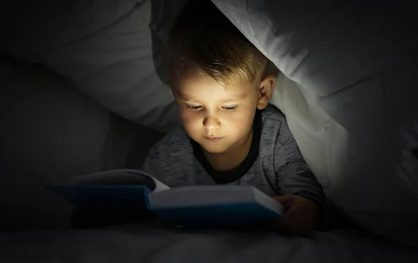 Aranyos Kisfiú Olvasókönyv Ágyban Takaró Alatt — Stock Fotó