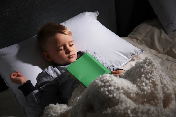 自宅のベッドで眠っている本とかわいい男の子 — ストック写真
