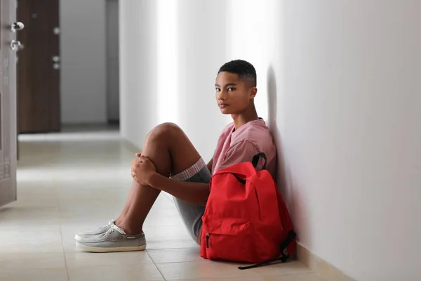 悲しいアフリカ系アメリカ人の 代の少年は屋内の床に座って 学校でのいじめ — ストック写真
