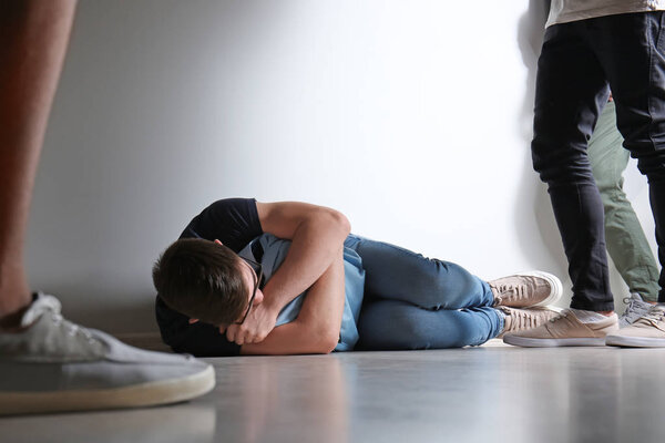 Агрессивные подростки издеваются над мальчиком в школе
