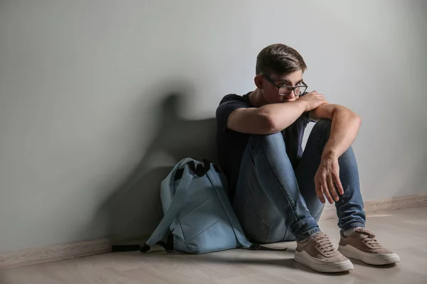 Sorgliga Tonårspojke Sitter Golvet Inomhus Mobbning Skolan — Stockfoto