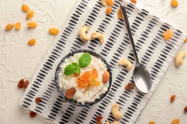 Kuruyemiş ve badem kase üzerinde masa lambası ile lezzetli sütlaç