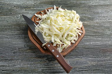 Ahşap tahta üzerinde bıçak ile rendelenmiş lahana