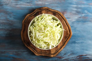 Ahşap tahta üzerinde rendelenmiş lahana ile kase