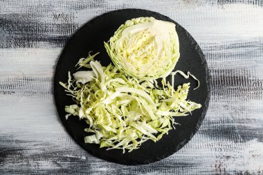 Ahşap masa üzerinde kesilmiş lahana ile kayrak plaka