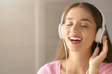 Evde müzik dinleyen güzel genç bir kadın.