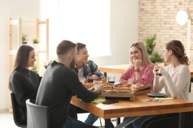 Gençler masada kapalı pizza yemek