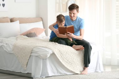 Baba ve oğlu birlikte evde kitap okuma