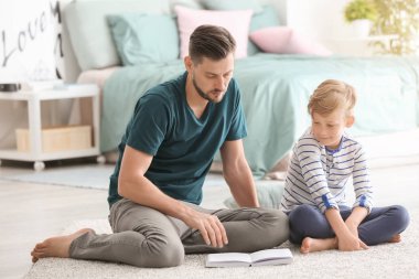 Baba ve oğlu birlikte evde kitap okuma