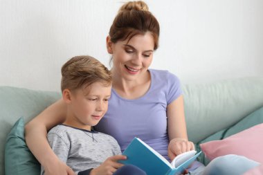 Anne ve oğlu birlikte evde kitap okuma
