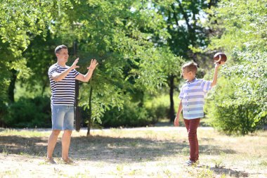 Açık havada Ragbi oynarken babası olan küçük çocuk