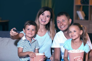 Mutlu aile akşam Tv izlerken patlamış mısır yemek