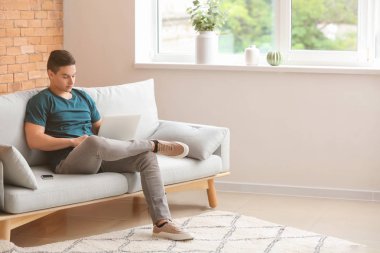 Evde dizüstü bilgisayarda çalışan genç bir serbest yazar.