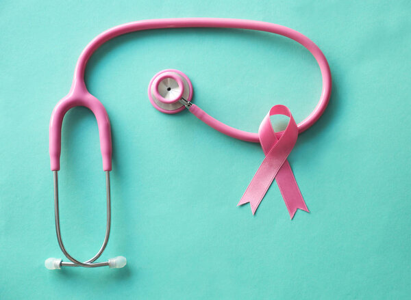 Pink ribbon and stethoscope on color background. Breast cancer awareness concept