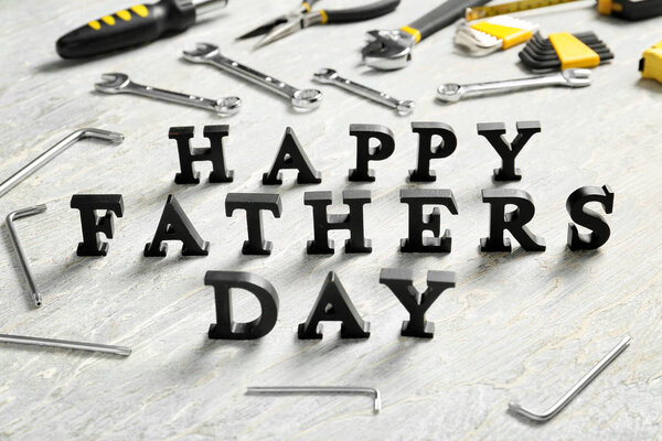 Phrase "Happy Father's Day" composed with letters and different tools on table