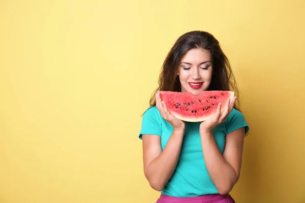 美丽的年轻妇女与切片的美味西瓜的颜色背景 — 图库照片