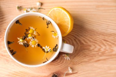 Ahşap masa üzerinde lezzetli papatya çayı fincan