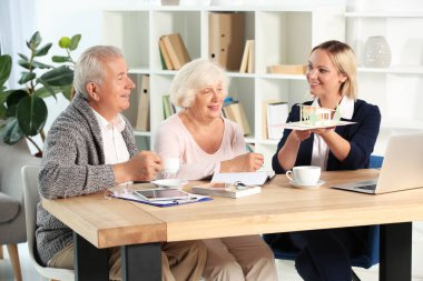 Evin ofisinde istemcilere emlakçı gösteren model