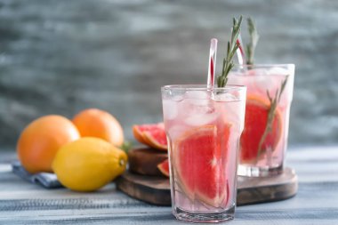 Taze greyfurt ahşap masa üzerinde bardaklarda rosemary ile kokteyl