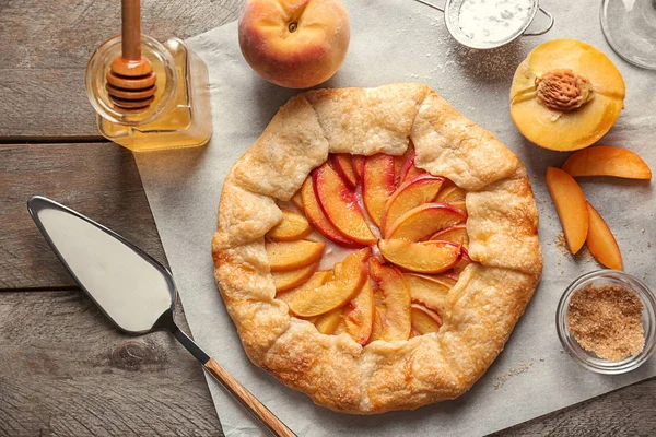 Pergament Mit Köstlicher Pfirsichgalette Auf Dem Tisch — Stockfoto