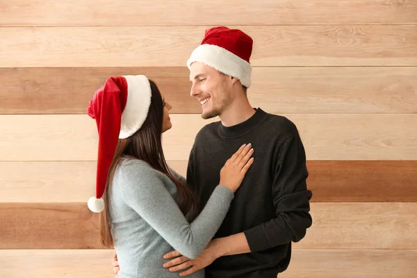 Retrato Bonito Jovem Casal Santa Chapéus Fundo Madeira — Fotografia de Stock