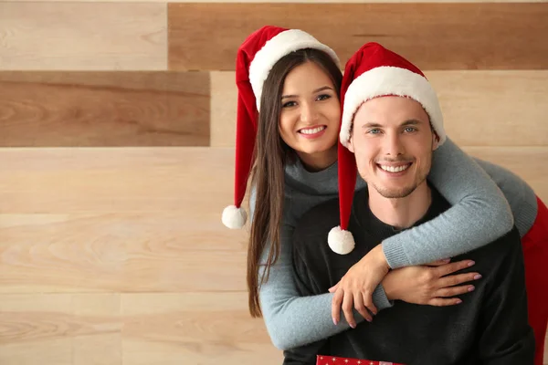 Retrato Linda Pareja Joven Sombreros Santa Sobre Fondo Madera — Foto de Stock