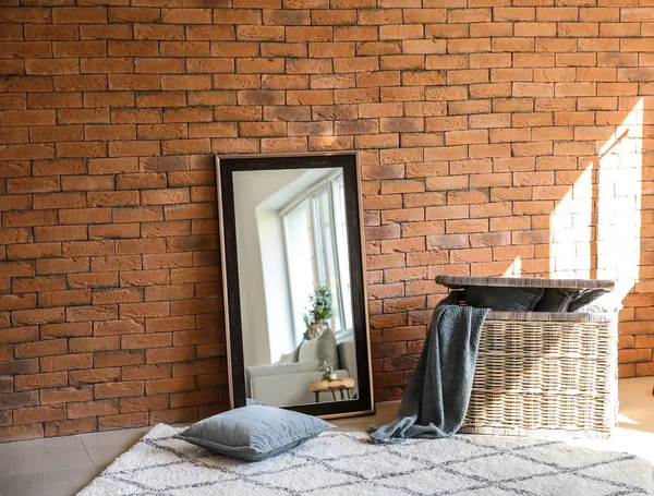 Büyük Şık Ayna Ile Hasır Sepet Yakın Tuğla Duvar Odasında — Stok fotoğraf