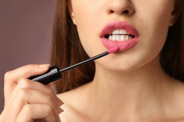 Pembe ruj rengi arka planda, closeup uygulama güzel genç kadın