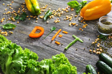 Sağlıklı sebze ve word ile kompozisyon üzerinde ahşap arka plan diyet