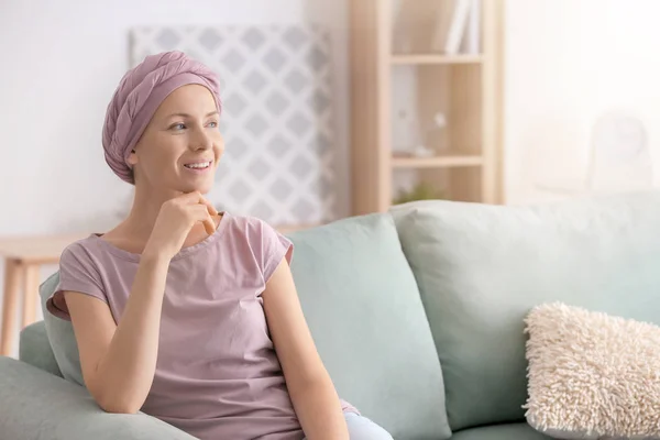 快乐的妇女化疗后坐在沙发上在家 — 图库照片