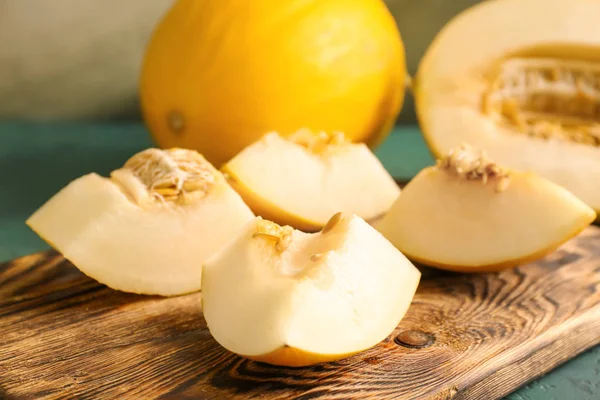 Board with ripe sliced melon on green table