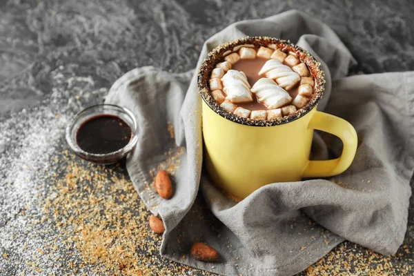 Cup of delicious cocoa with marshmallows on grey table
