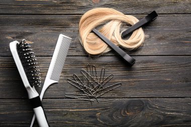 Profesyonel kuaför sarışın saç teli ile ahşap arka plan üzerinde ayarlandı