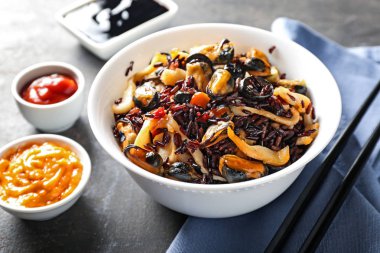 Haşlanmış pirinç ve deniz ürünleri gri tablo ile kase