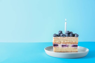 Bir renk arka plan üzerinde mum yanan ile lezzetli Doğum günü pastası