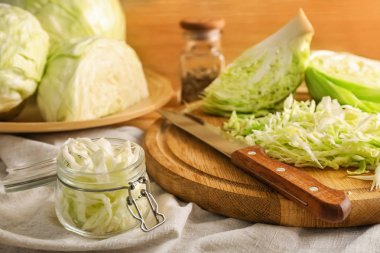 Kavanoz ve ahşap tahta masada rendelenmiş lahana ile