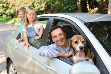 Mutlu aile ile arabada oturan sevimli köpek