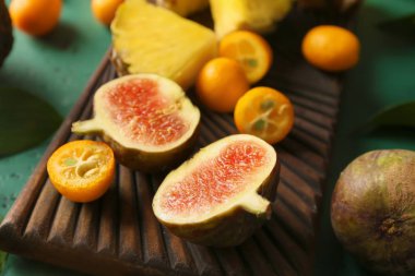 Renk tablosu üzerinde çeşitli lezzetli egzotik meyve ile ahşap tahta