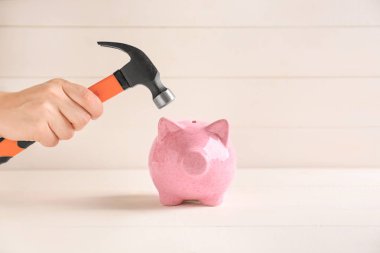 Kumbara hafif ahşap zemin üzerinde çekiç tutan kadın