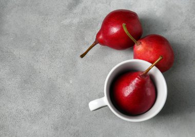 Kupası ve gri masada lezzetli olgun armut