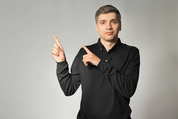 Hombre Guapo Señalando Algo Sobre Fondo Gris — Foto de Stock