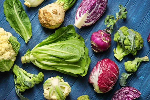 Different types of cabbage on color wooden background — Stock Image Different Types Cabbage Color Wooden Background Stock Picture