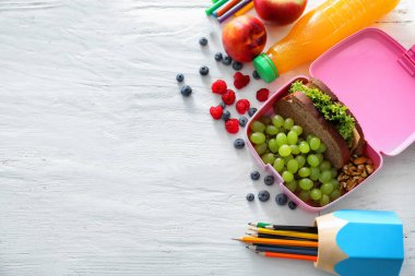 İştah açıcı gıda ve Kırtasiye Beyaz ahşap masa üzerinde öğle yemeği kutusu