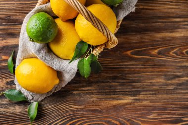 Ahşap masa üzerinde olgunlaşmış limon ile hasır sepet