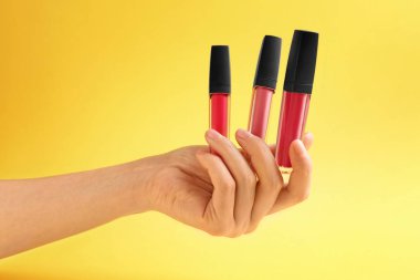 Sıvı rujları renk arka plan üzerinde tutan kadın