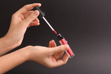 Likit ruj gri arka plan üzerinde tutan kadın