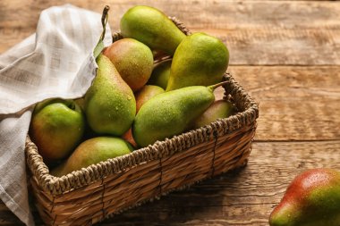 Ahşap masa üzerinde olgun tatlı armut ile hasır kutu