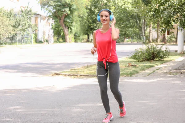 Sporty Young Woman Listening Music While Running Outdoors — Stock Photo, Image