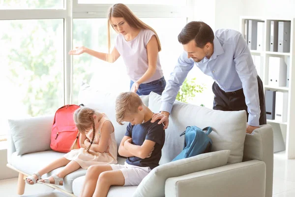 Displeased parents and their children after meeting with headmaster at school